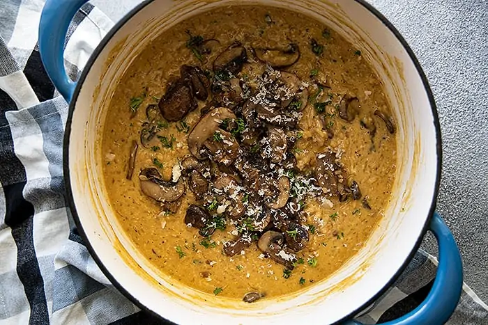 Overhead view of easy mushroom risotto garnished with parsley and parmesan cheese. 