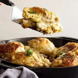 Lifting a portion of the casserole out of the pan ready to serve onto a plate.