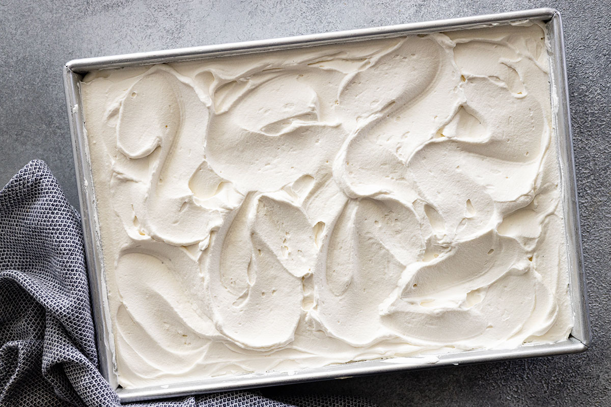 Whipped cream spread over the cake.