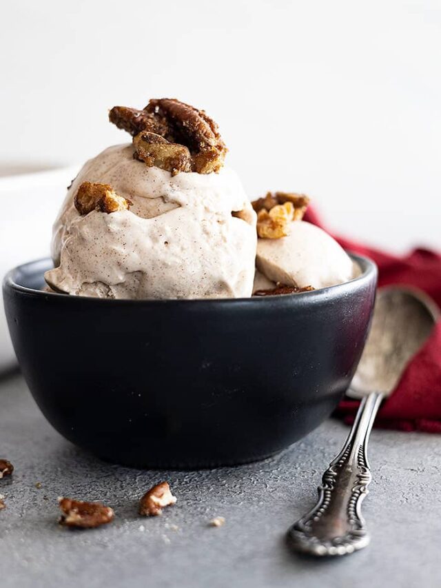 A bowl of cinnamon ice cream topped with candied pecans.