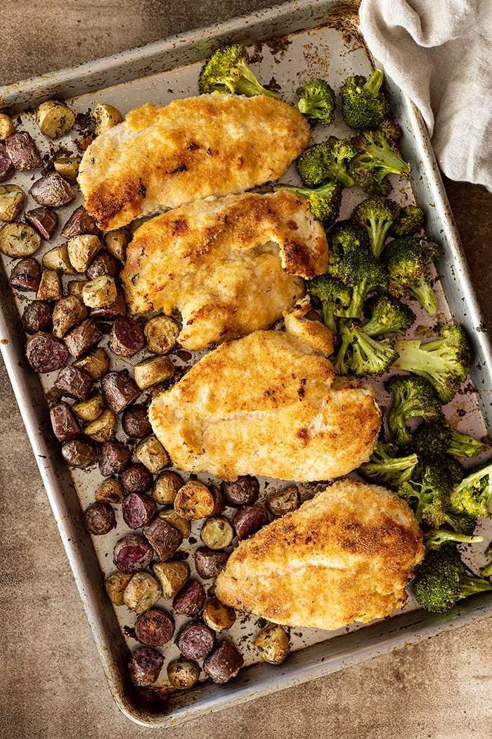 Overhead view of sheet pan dinner fresh from the oven. Tan towel in the corner. 