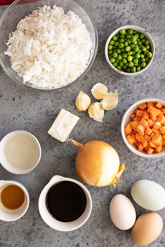 Rice, peas, carrots, garlic, butter, soy sauce, onion, egg, sesame oil are used to make fried rice.