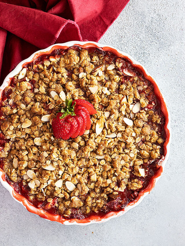 Overhead view of strawberry crisp fresh from the oven with a fresh strawberry fanned out on top for garnish.