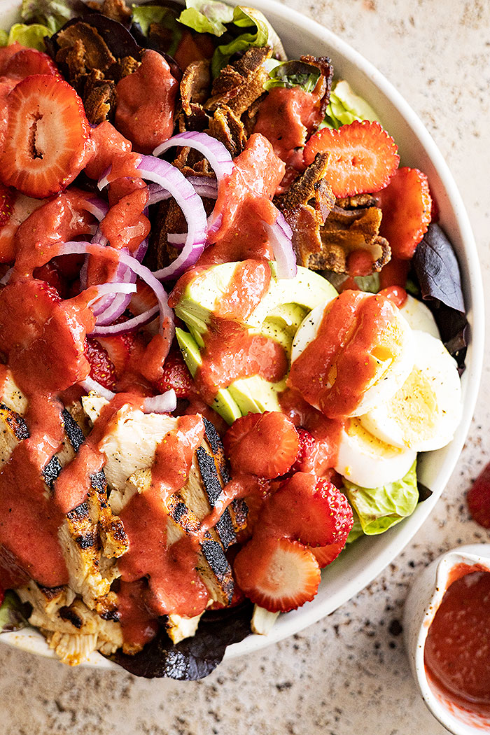 Close up of strawberry cobb salad drizzled with the strawberry vinaigrette.