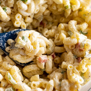 Close up of Macaroni Salad in a bowl with a spoon.