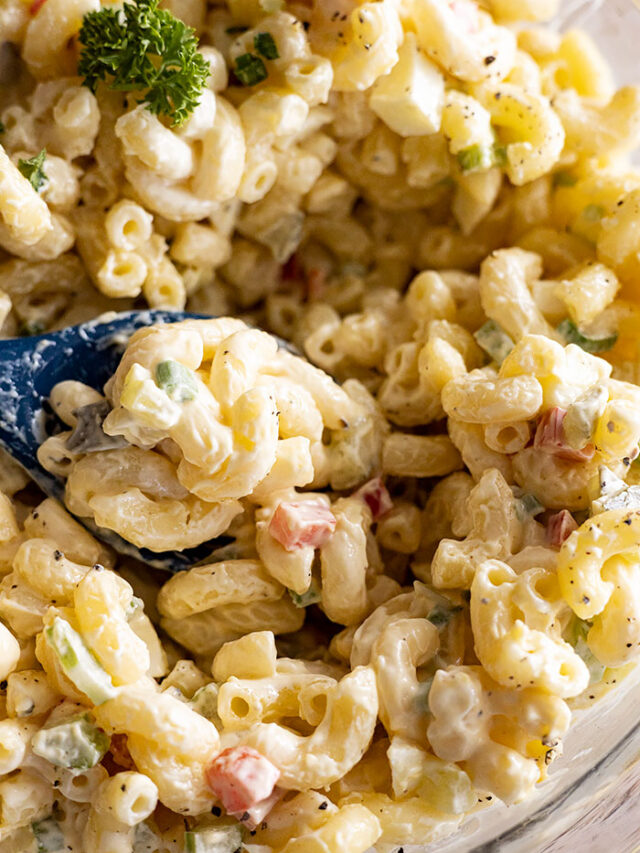 Close up of Macaroni Salad in a bowl with a spoon.