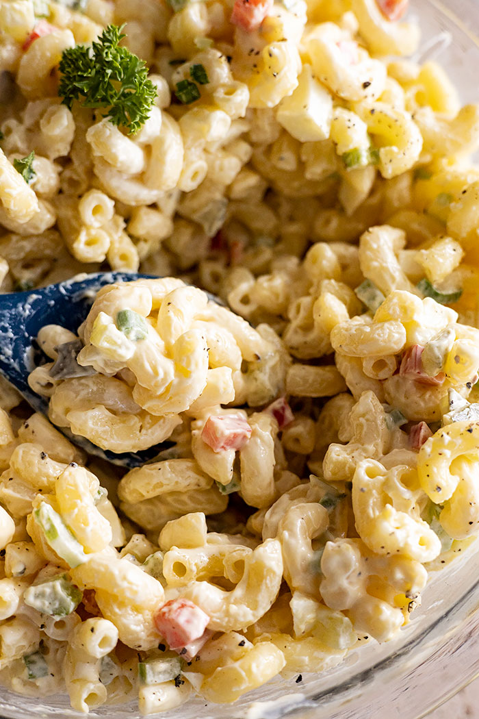 Close up of Macaroni Salad in a bowl with a spoon. 