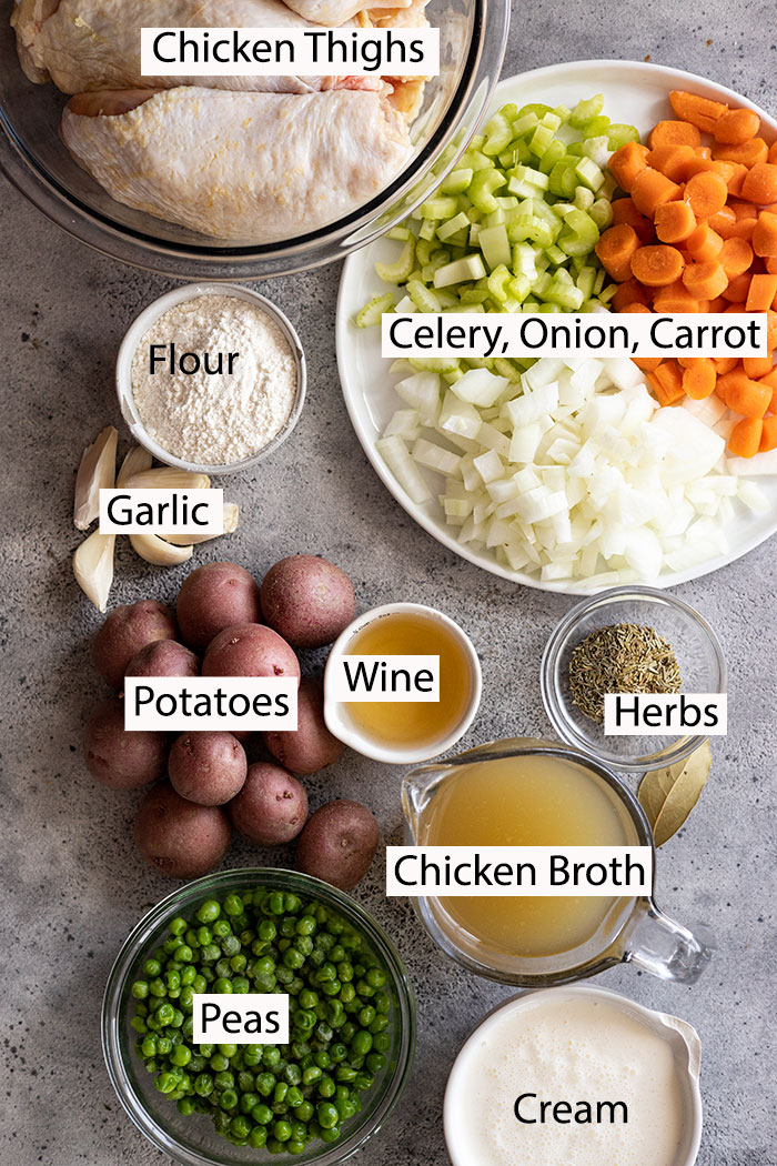 Ingredients to make creamy chicken stew: chicken thighs, celery, onion, carrot, garlic, flour, chicken broth, herbs, potatoes, cream and white wine.