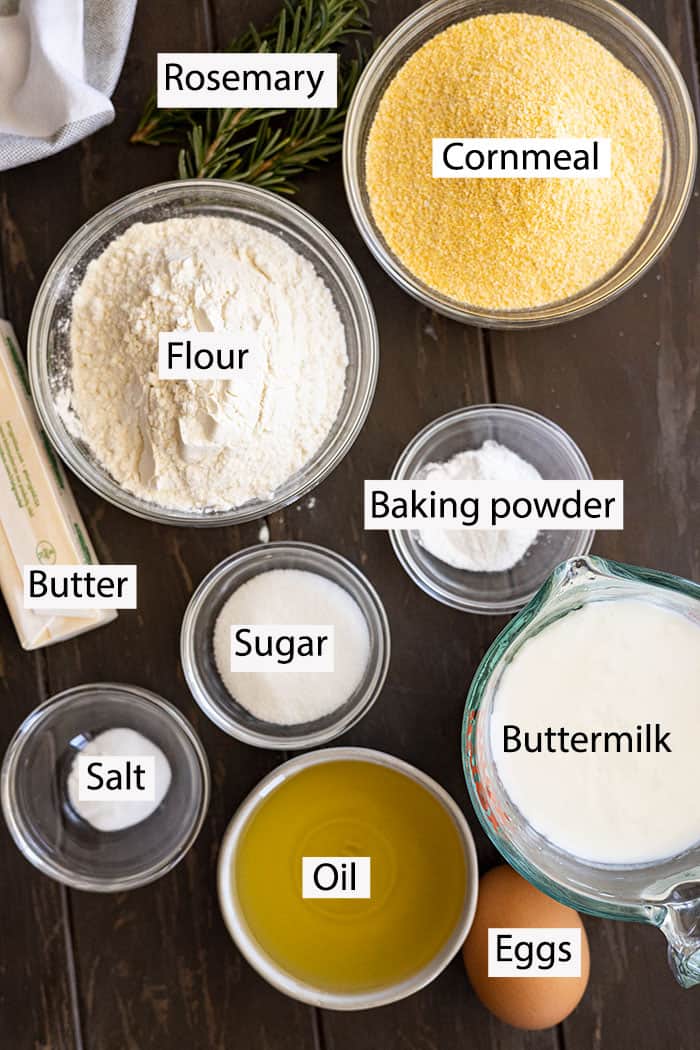 Ingredients for rosemary cornbread: rosemary, cornmeal, flour, butter, sugar, baking powder, salt, buttermilk, eggs, and oil.