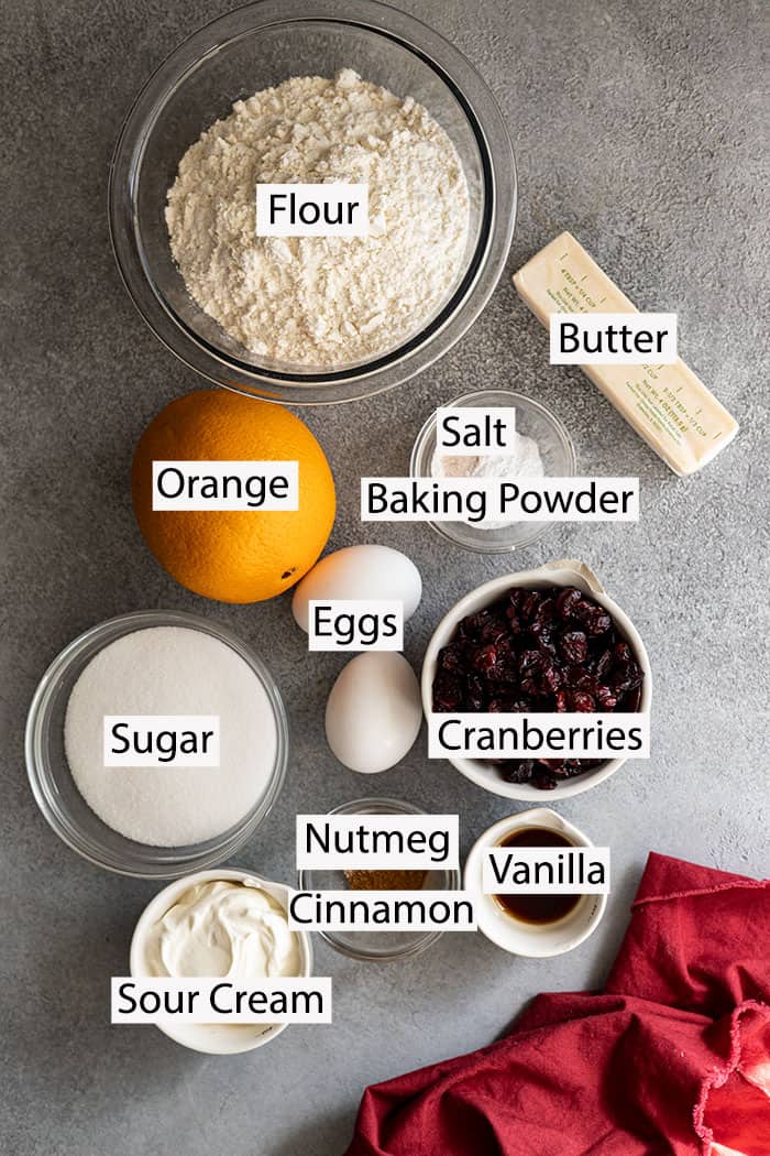 Ingredients: flour, butter, orange zest, orange juice, salt, baking powder, eggs, sugar, sour cream, nutmeg, cinnamon, vanilla, and cranberries.