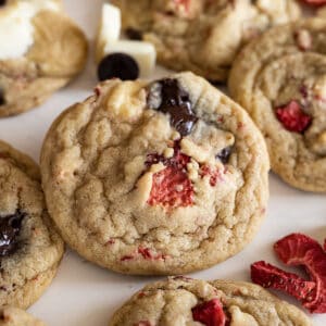 Strawberry chocolate chips cookie surrounded by other cookies.