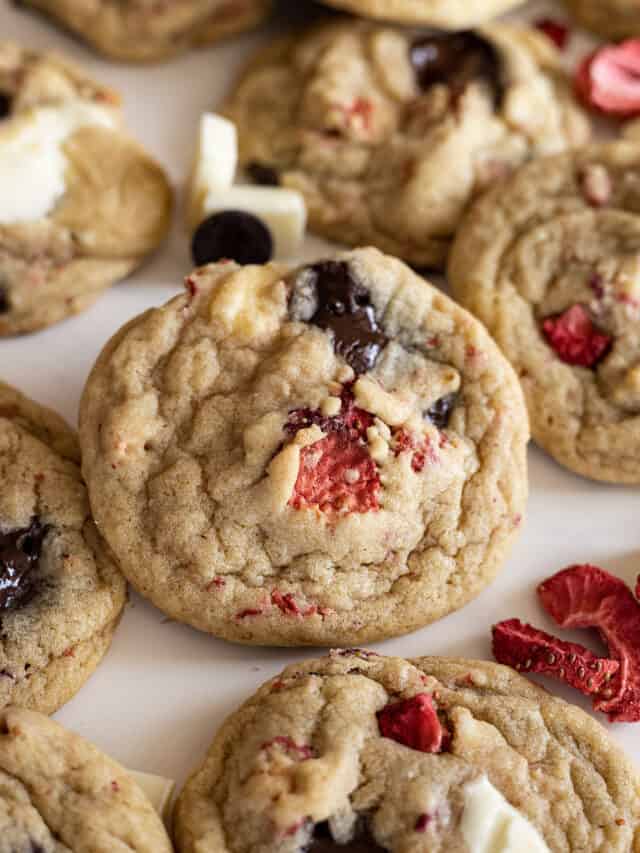 Strawberry chocolate chips cookie surrounded by other cookies.