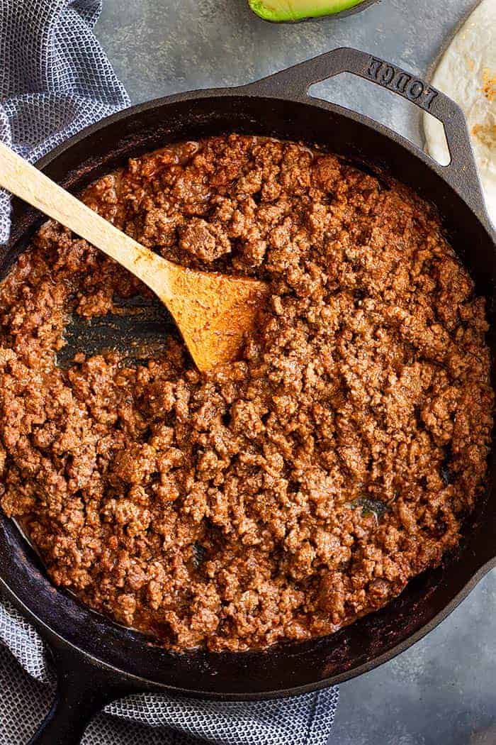 A cast iron skillet full of ground beef taco meat.