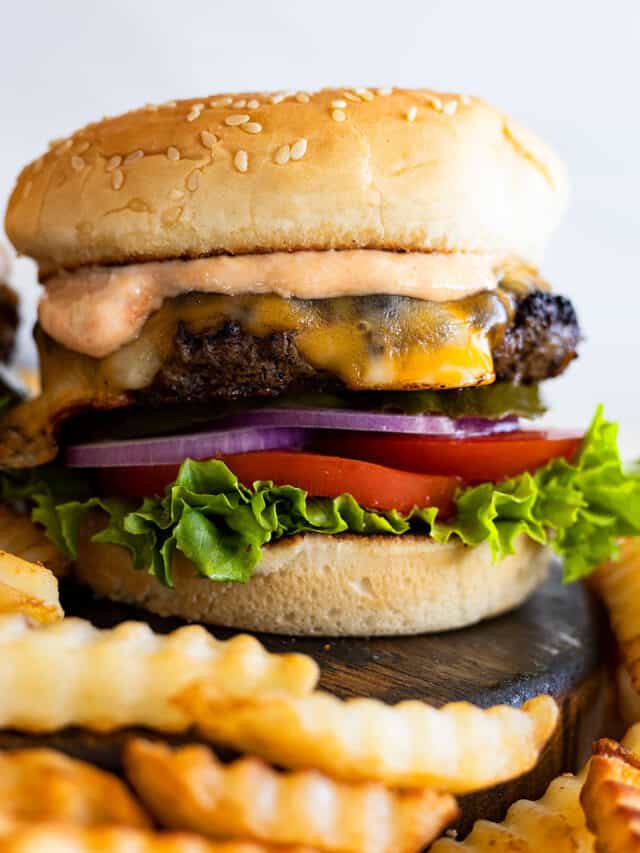 The classic burger piled high with toppings and burger sauce. Fries off to the side.