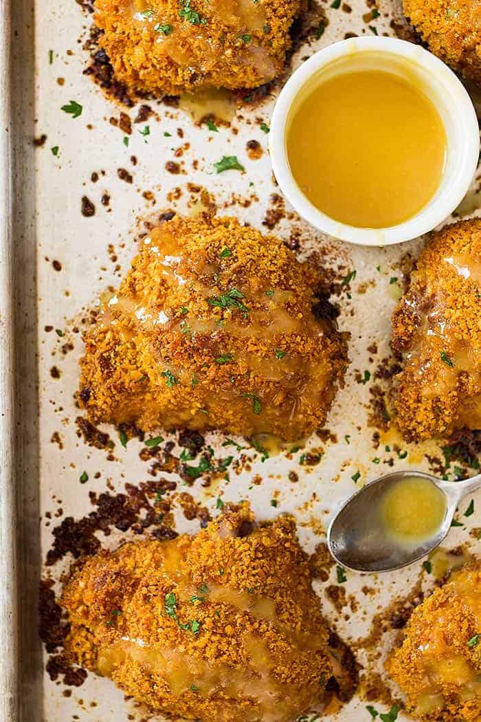 overhead view of crispy breaded chicken thighs with a honey mustard sauce drizzled on top