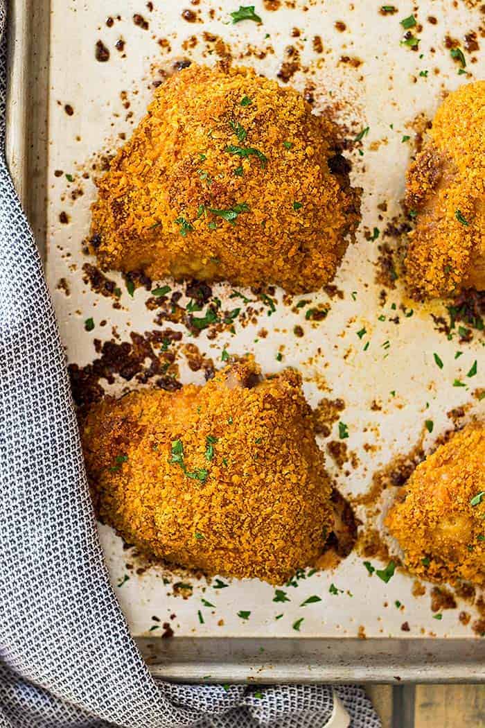 overhead view of crispy oven fried chicken thighs on a sheet pan