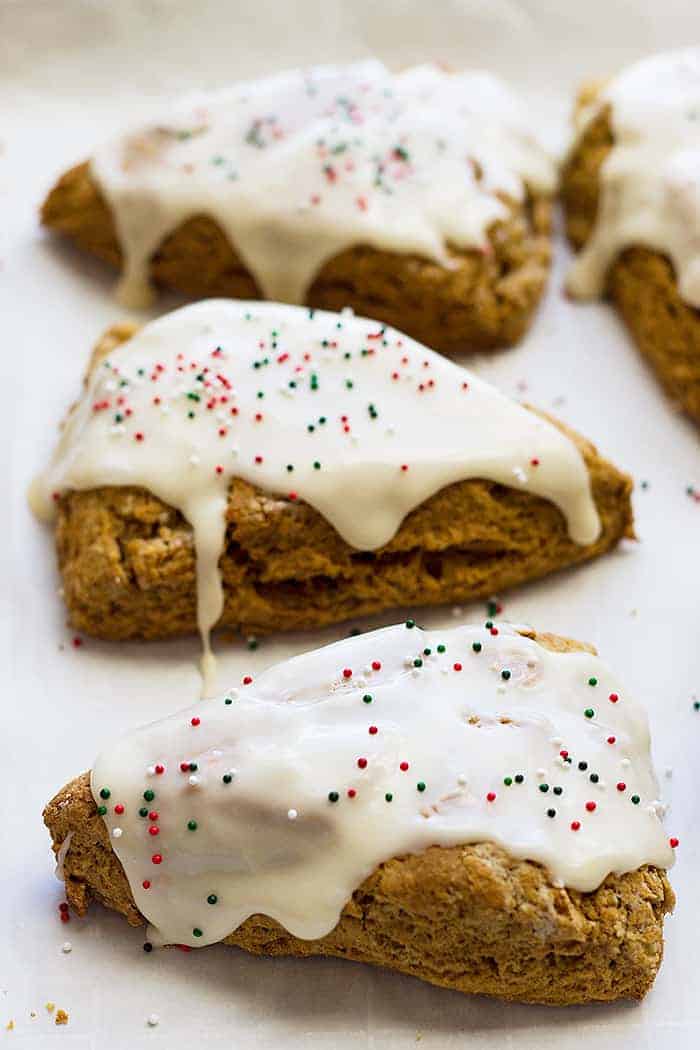 4 gingerbread scones with cream cheese frosting and sprinkles on top