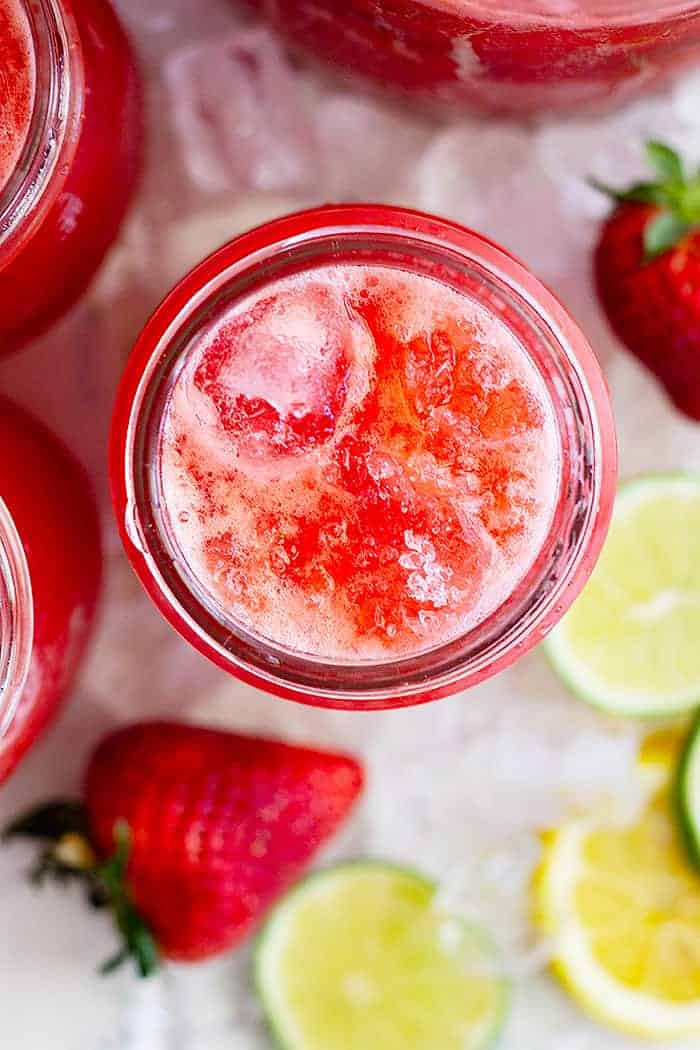 overhead closeup: a glass of strawberry lemonade margarita with coarse salt on top