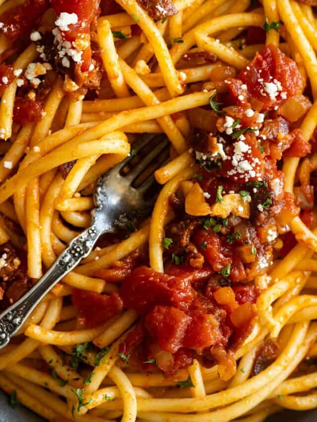 Close up of pasta garnished with cheese and parsley.