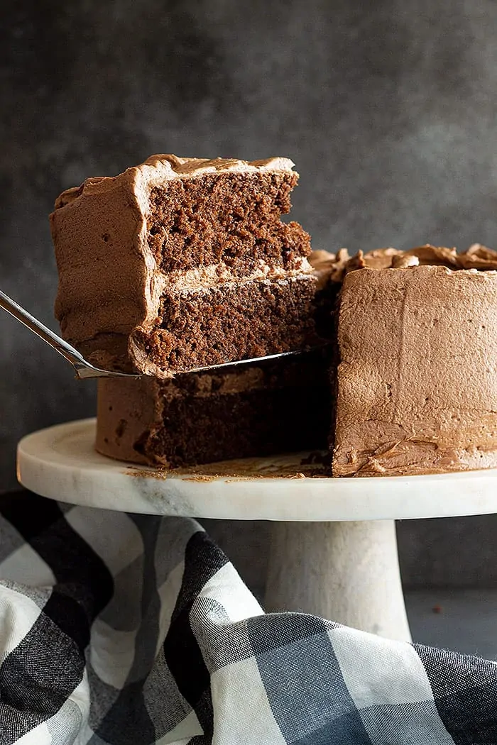 serving a slice of frosted chocolate layer cake
