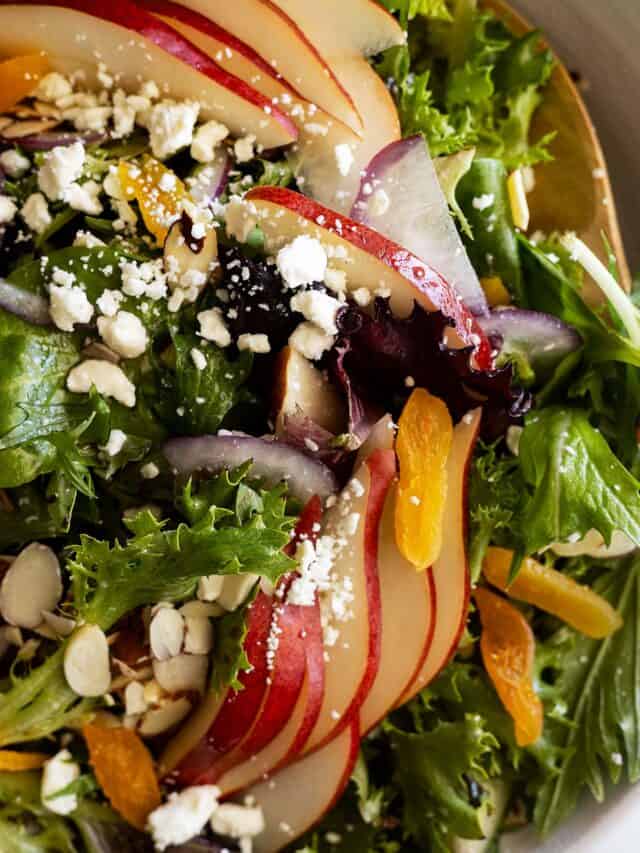 Close up of pear salad with dried apricots, feta, and sliced almonds.