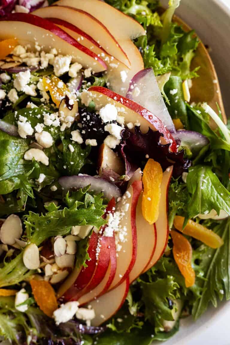 Close up of pear salad with dried apricots, feta, and sliced almonds.