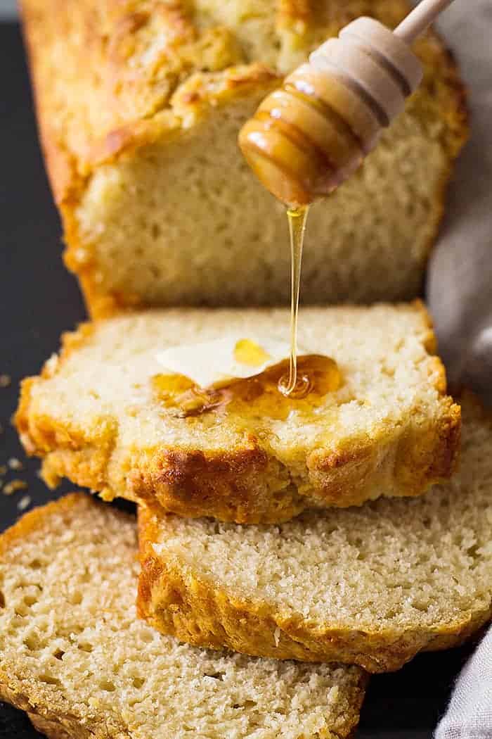 closeup: pouring honey over slices of this easy beer bread recpe