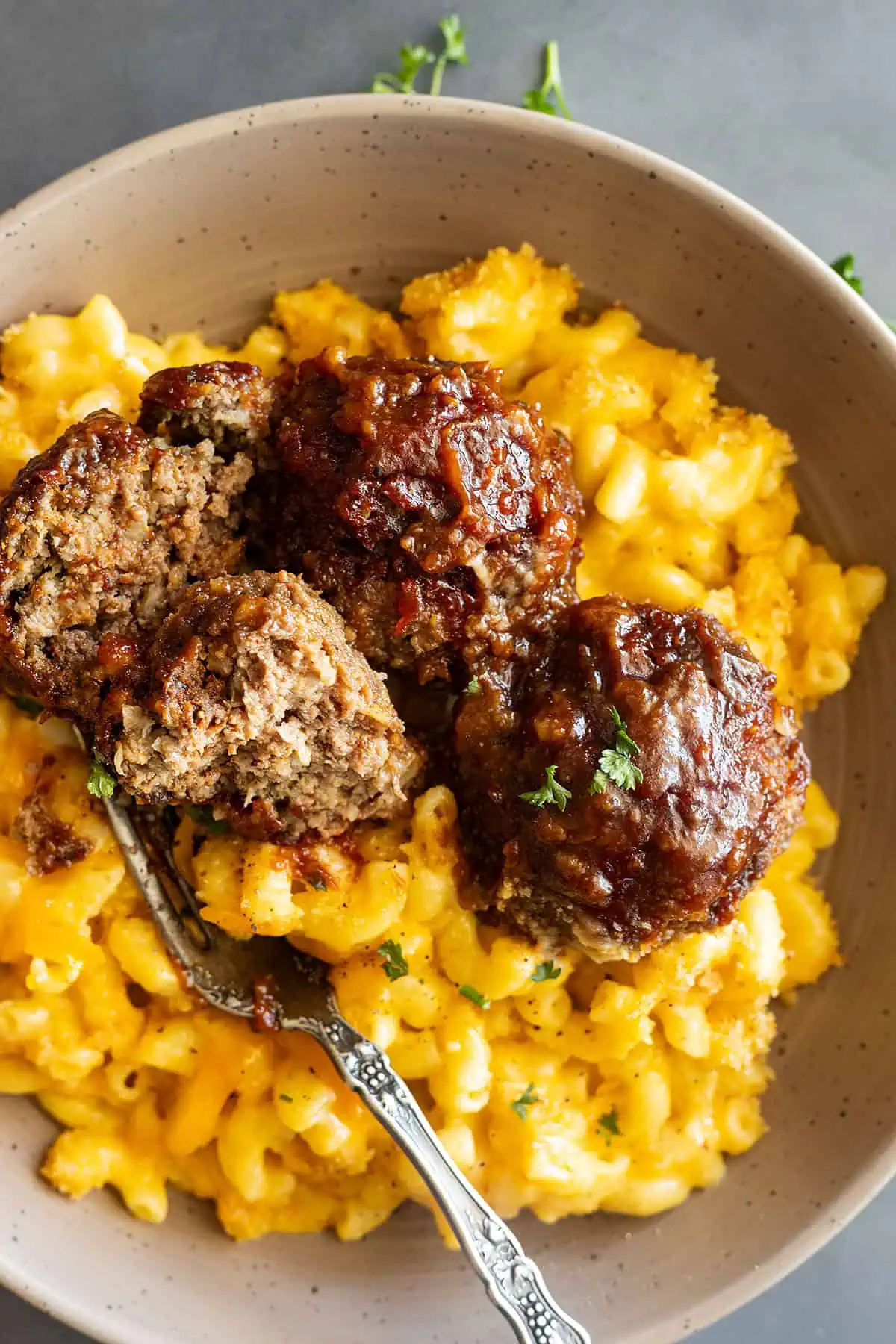 overhead: BBQ meatballs in oven over mac and cheese in a bowl