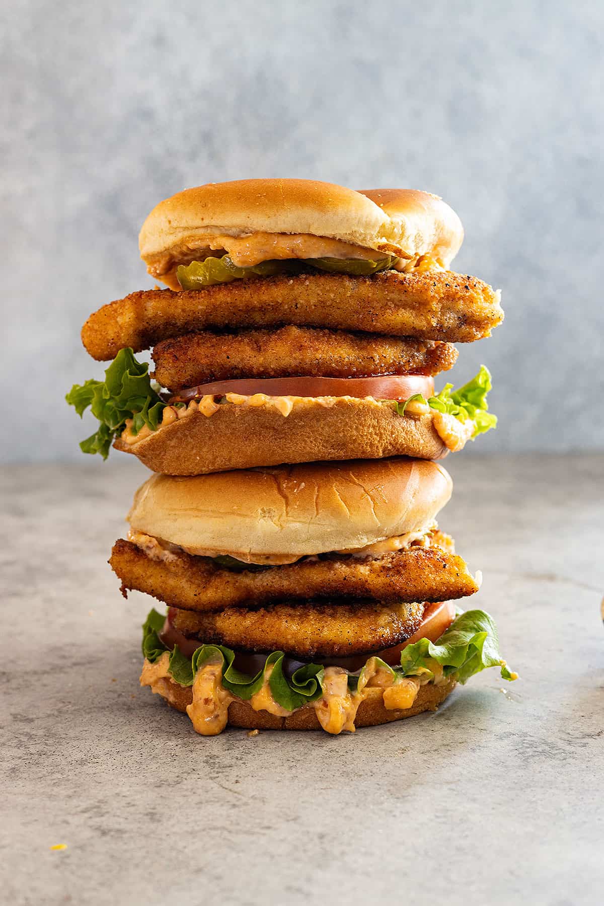Two chicken sandwiches stacked on top of each other. 