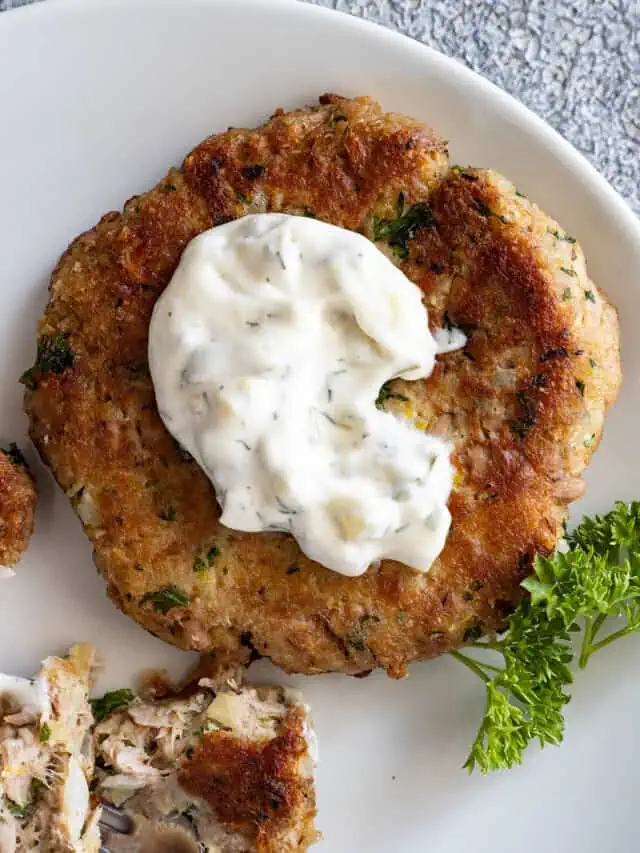 Overhead view of tartar sauce on a tuna patty.