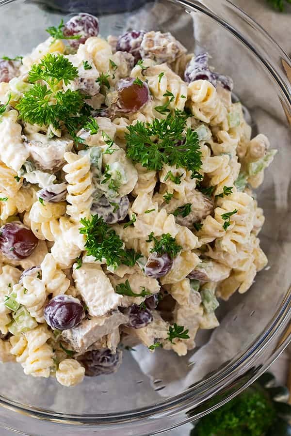 overhead: a bowl of chicken pasta salad with grapes and fresh herbs showing