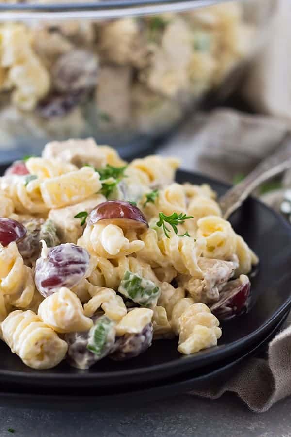 closeup: pasta salad with chicken and grapes on black plate