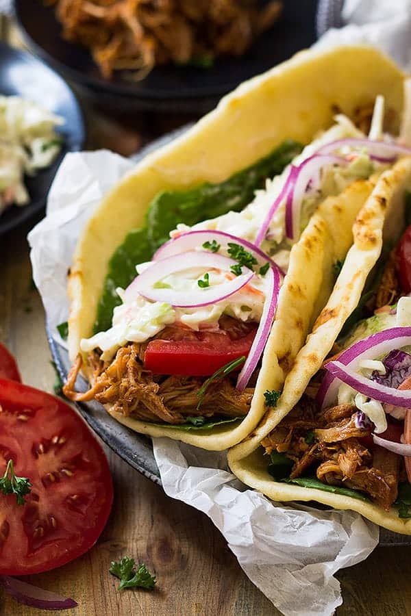 closeup: pork gyros recipe made with flatbread with meat, tomato, and coleslaw inside