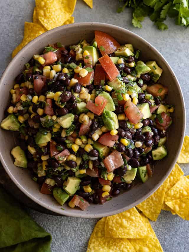 Overhead picture of salsa in a large bowl with chips scattered around.