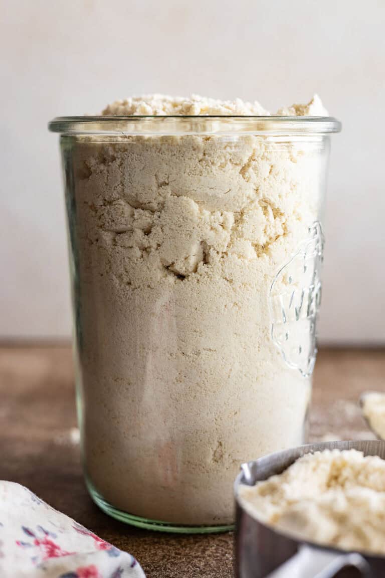 A tall clear glass jar filled with homemade bisquick.