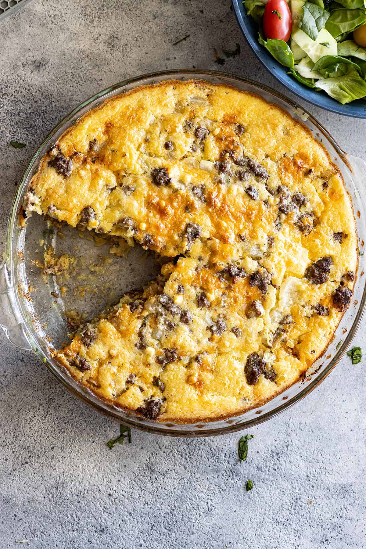 Overhead view of cheeseburger pie with a slice taken out.