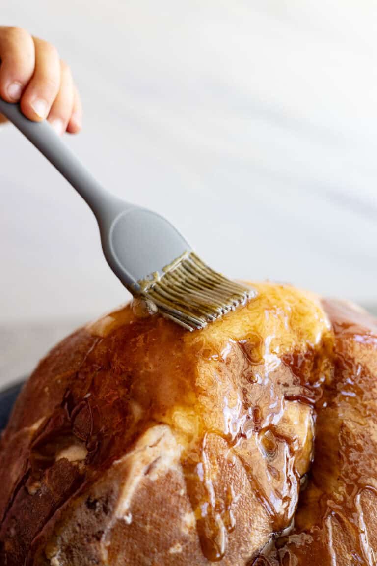 A brush adding glaze to a ham.