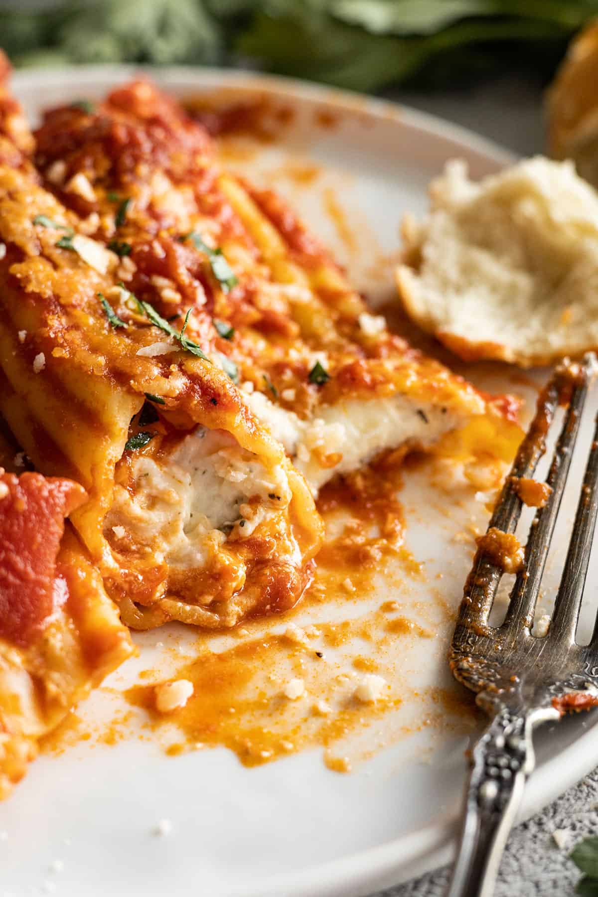 Close up of a bite taken out of cheese manicotti showing the cheesy inside. 