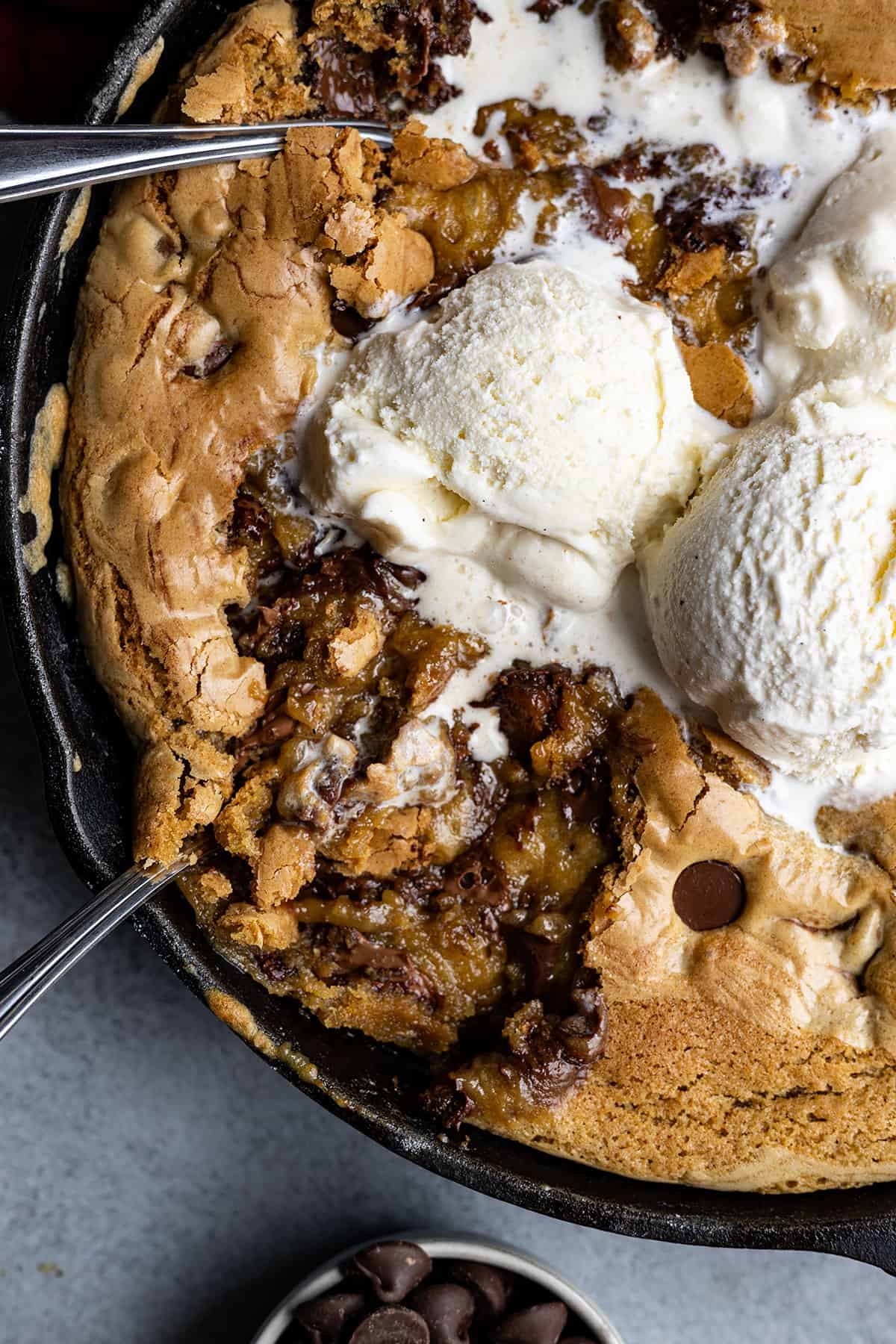 A skillet filled with a gooey cookie and ice cream.