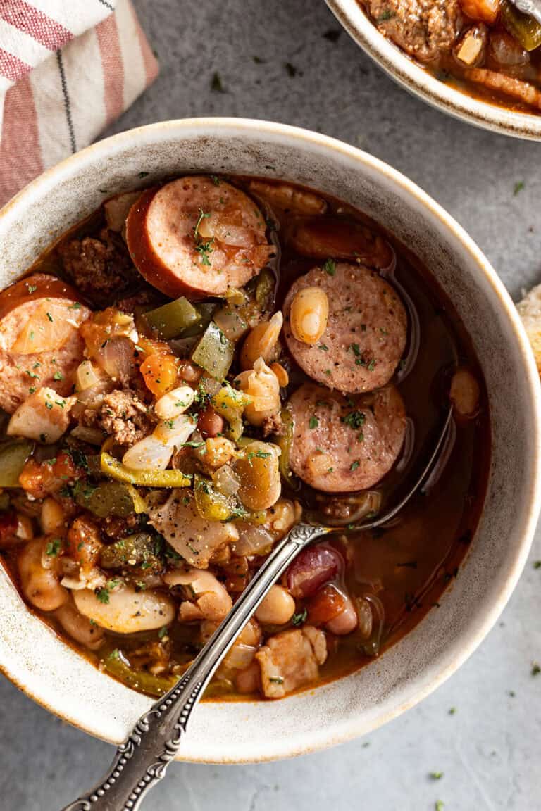 close up of soup in a bowl with spoon. napkin off to the side.