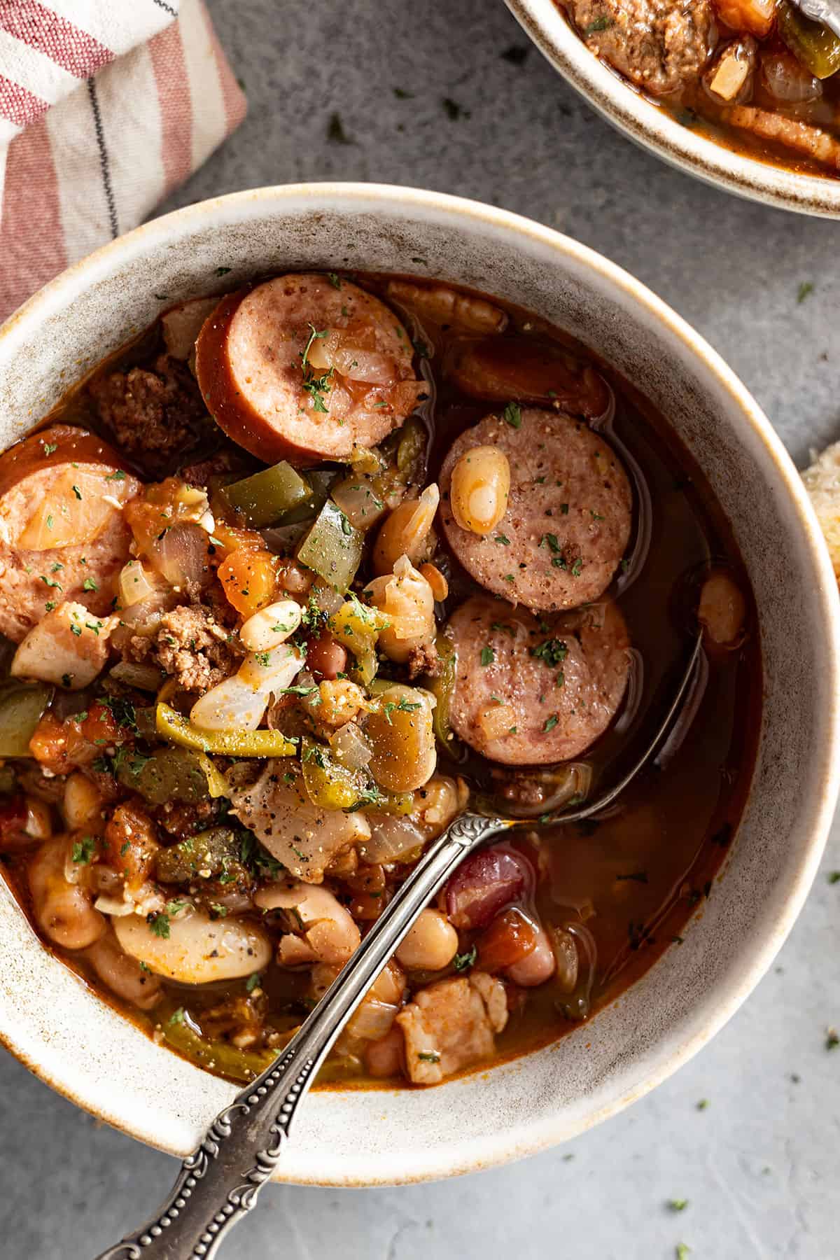 close up of soup in a bowl with spoon. napkin off to the side.