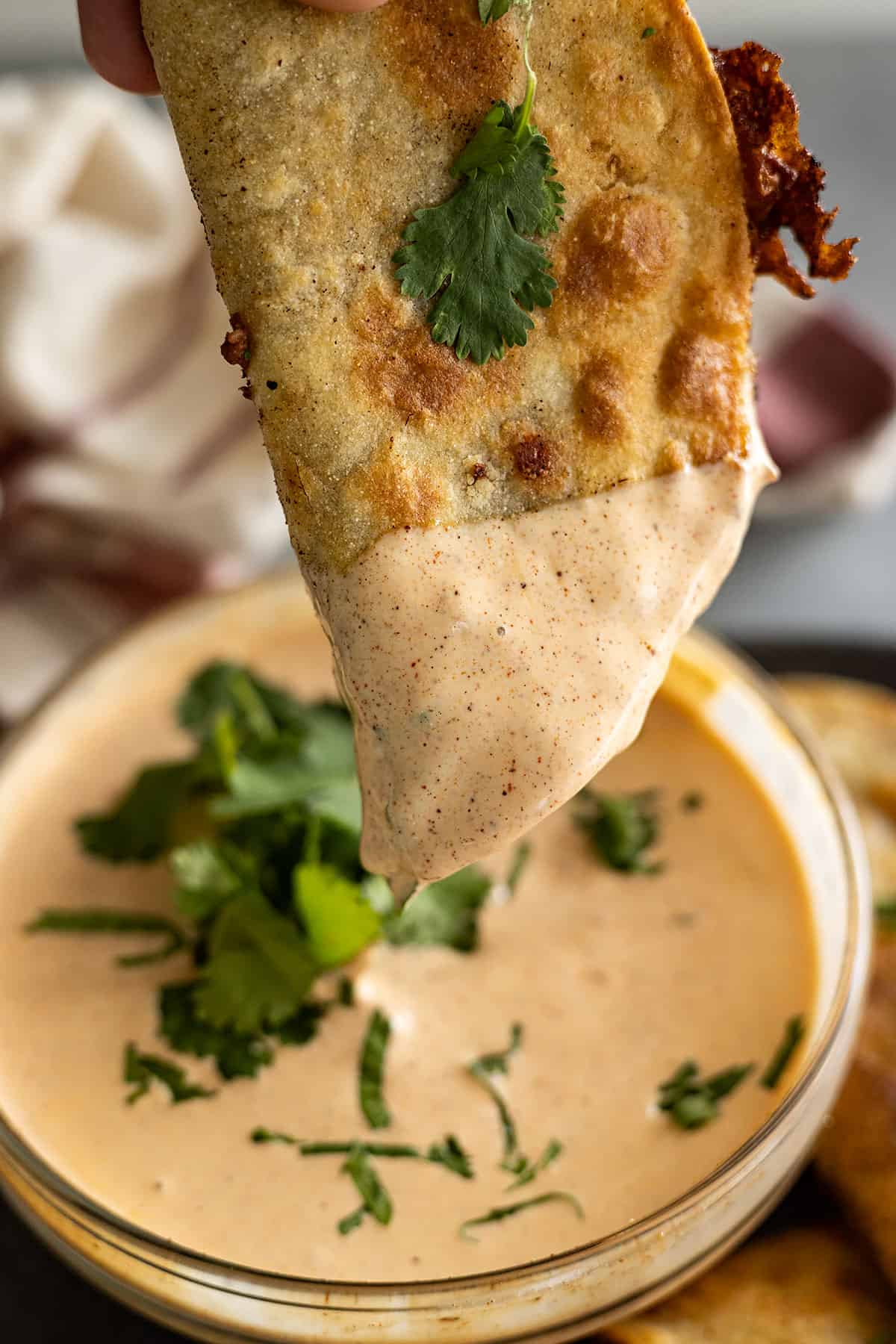 Taco being dipped into a creamy taco sauce.