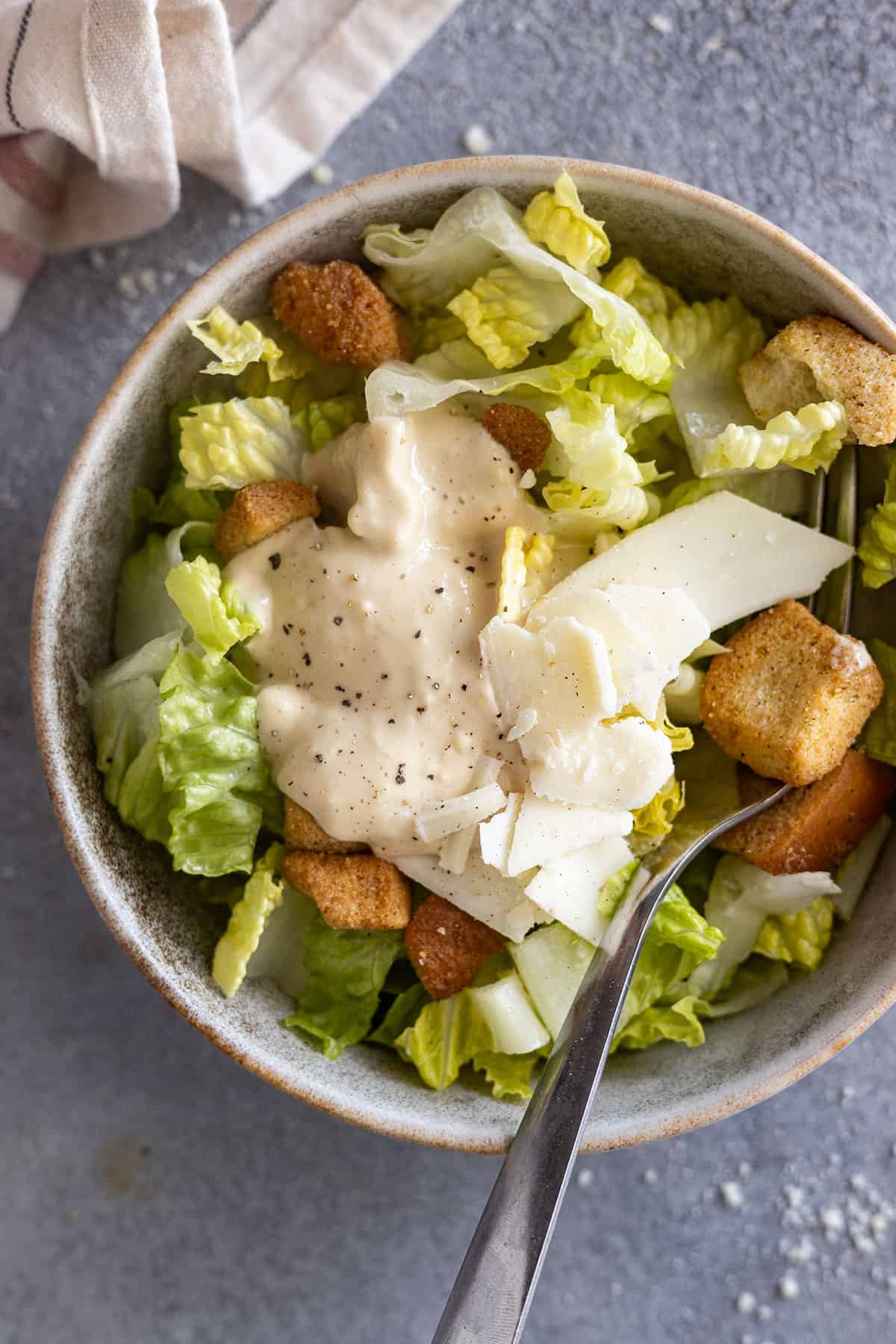 homemade caesar dressing on top of a salad.