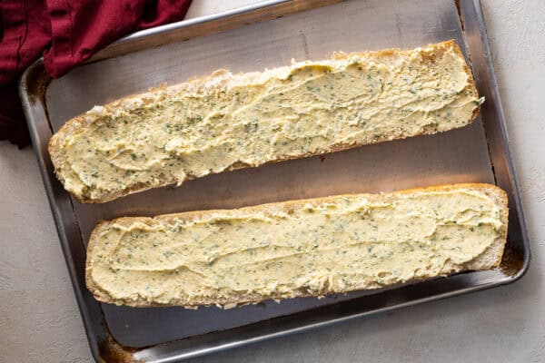 Garlic butter spread over two halves of French bread.