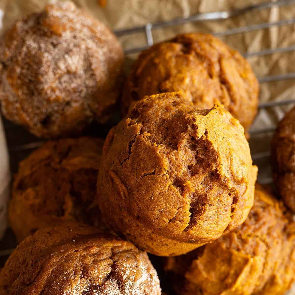 Overhead view of several pumpkin muffins piled together.